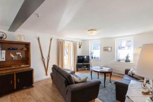 a living room with a couch and a table at Ferienhaus Lauwenhaus mit Sauna und eingezäunten Garten in Braunlage