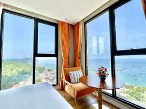 Camera con letto, tavolo e finestre di LYNS Apartment - Ocean View with Infinity Pool &Firework a Phu Quoc