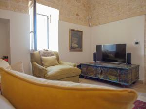 a living room with a couch and a television at Casa Pietra Bianca Fay in Castellana Grotte