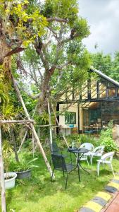a patio with a table and chairs in front of a house at โอรีสอร์ต Oresort in Ban Chua Phloeng