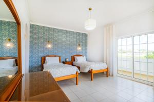 ein Schlafzimmer mit zwei Betten und einem Spiegel in der Unterkunft Filomena Golf Paradise in Guia + 35 Fotos