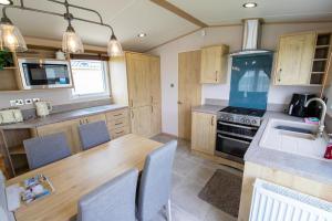 a kitchen with a wooden table and a sink at MP724 - Parkdean Camber Sands in Camber