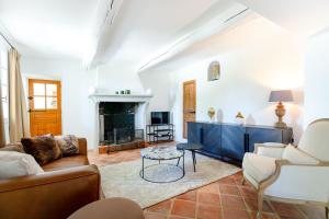 een woonkamer met een bank en een open haard bij Propriété d'exception - Piscine et Tennis in Venelles