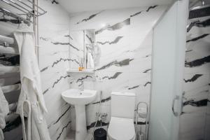 Un baño blanco con lavabo e inodoro. en Old City Home, en Baku 23 fotos más