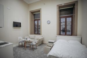 Un dormitorio blanco con una cama y una sala de estar. en Old City Home, en Baku