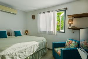 a bedroom with a bed and a window and a chair at Pousada AGUA SALGADA in Jericoacoara