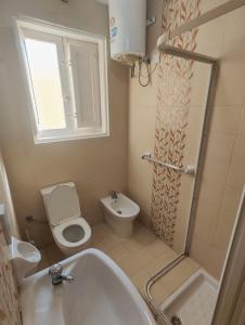 a bathroom with a tub and a toilet and a sink at House next to sea, grand & unique Maltese style in St Paul's Bay