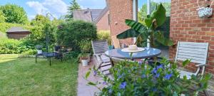 a patio with a table and chairs in a garden at Bed vue sur vallée de la Meuse Namur in Bouge