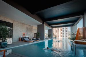a group of people swimming in a pool in a building at Shō Hotel Penang in George Town