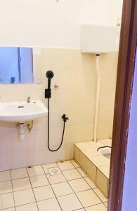 a bathroom with a sink and a toilet at iLham Homestay in Kangar +36 photos
