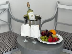 a bottle of wine and a plate of fruit on a table at Napa Jay Hotel in Ayia Napa