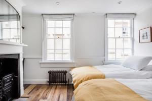 two beds in a white bedroom with windows at Central Georgian Townhouse with Free Parking in Bath +31 photos