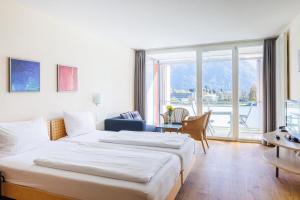 a hotel room with two beds and a large window at Hapimag Ferienwohnungen Interlaken in Interlaken +57 photos