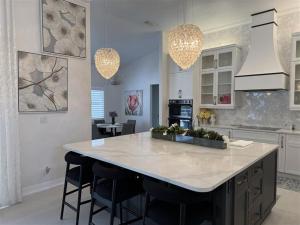 a kitchen with a large island in the middle of a room at Heated Pool & Tiki Hut on a Stunning Canal View - The Dancing Dolphin Villa - Roelens in Cape Coral