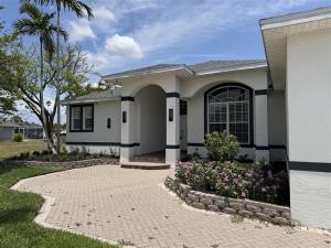 a house with a brick driveway in front of it at Heated Pool & Tiki Hut on a Stunning Canal View - The Dancing Dolphin Villa - Roelens in Cape Coral