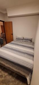 a bedroom with a bed with striped sheets at Casa Fundo de Quintal in Baía Formosa