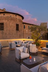 a rooftop patio with white chairs and tables at Room Mate Collection Mia, Rome Colosseum in Rome +38 photos
