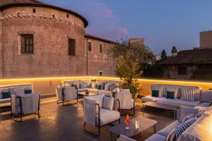 a patio with couches and tables and a building at Room Mate Collection Mia, Rome Colosseum in Rome