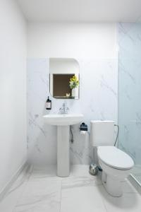 a white bathroom with a sink and a toilet at Апарт-отель MICH8 by KEYGO in Yerevan +107 photos