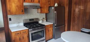a kitchen with stainless steel appliances and wooden cabinets at Small-town bungalow downtown in Pineville