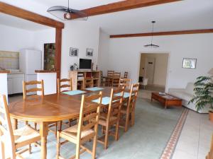 una sala da pranzo e un soggiorno con tavolo e sedie in legno di Le Logis de la Venise Verte a Saint-Hilaire-la-Palud