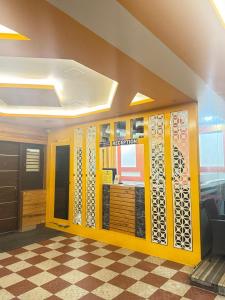 a lobby with a yellow wall and a checkered floor at SUPREME SUITs in Jāmb
