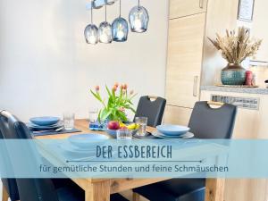 a dining room table with blue bowls and chairs at Höfthus 9 Holla die Boddenfee Meerblick Terrasse mit Hund die Natur genießen in Alt Reddevitz +8 photos