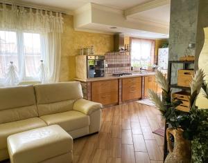 a living room with a couch and a kitchen at VILLA DAL PESCATORE Apartment - Elegant Retreat between Anzio & Nettuno with Garden and refined Patio - Train Station 500mt in Nettuno