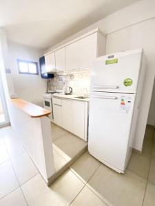 コンセプシオン・デル・ウルグアイにあるVH apartsの白いキャビネットと白い冷蔵庫のあるキッチン