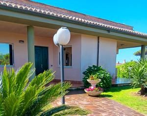 a house with a street light in front of it at VILLA DAL PESCATORE Apartment - Elegant Retreat between Anzio & Nettuno with Garden and refined Patio - Train Station 500mt in Nettuno