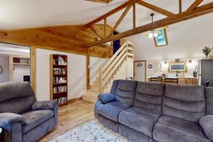 a living room with two couches and a staircase at Maine Lake Family Retreat in Monmouth