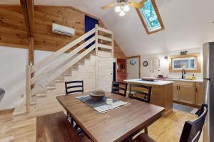 a kitchen and dining room with a wooden table and stairs at Maine Lake Family Retreat in Monmouth