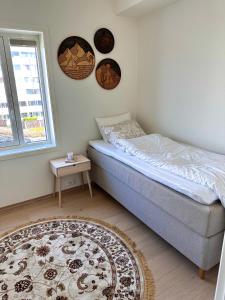 a bedroom with a bed and a window and a rug at Stor leilighet sentralt i Sandnes in Sandnes