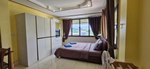 a small bedroom with a bed and a window at Rawai Condotel 3 in Rawai Beach