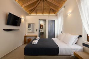 a bedroom with a bed with a teddy bear on it at Archontiko Residence in Koskinou +8 photos