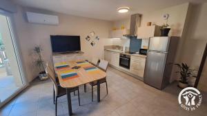 a kitchen with a table with chairs and a refrigerator at Le rodin in Albi