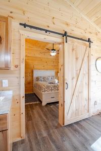a log cabin with a bed in a room with a door at Cozy Cabin Getaway! in Fancy Gap