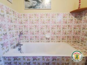 wanna w łazience z różowymi kwiatami w obiekcie Le janabel w mieście Prades-sur-Vernazobre +8 zdjęć