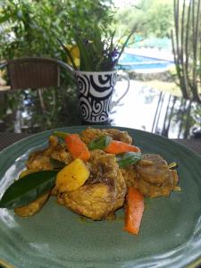 un piatto verde con carne e verdure su un tavolo di La Pernela Resort a Dauis