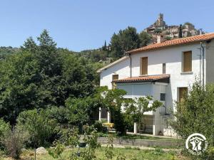 a white house with a hill in the background at Ribelles in Eus