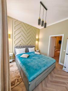 een slaapkamer met een groot blauw bed in een kamer bij Olive Apartment 1 - w Free Parking, self-checkin, 5 min from Aquapark Nymphaea in Oradea
