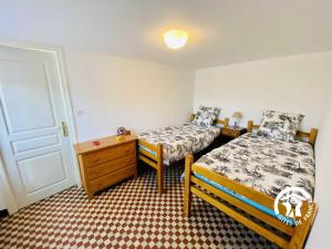 VillemoustaussouにあるAu bien-etreのベッドルーム1室(ベッド2台、ドレッサー、ドア付)