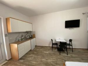 a room with a kitchen and a table with chairs at Gray&Oli Studios in Vlorë
