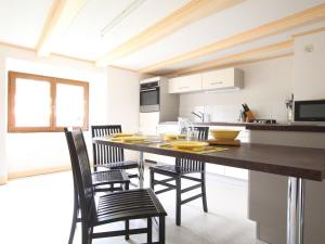 una cucina con tavolo e sedie in una cucina di Gîte pittoresque en bord de rivière avec jardin clos, proche sports et sites touristiques - FR-1-582-176 ad Alleyras