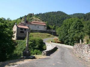 una strada con un edificio sul fianco di una collina di Gîte pittoresque en bord de rivière avec jardin clos, proche sports et sites touristiques - FR-1-582-176 ad Alleyras