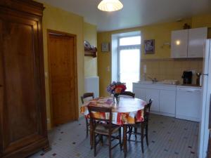 a kitchen with a table with a vase of flowers on it at Charmante Longère Gâtinaise - Cour et Jardin Clos, Proche Paris et Orléans - FR-1-590-73 in Sceaux-du-Gâtinais +5 photos