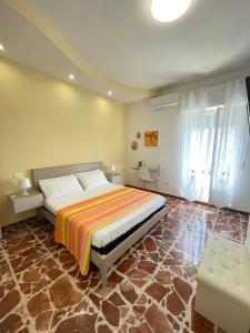 a bedroom with a large bed and a couch at Acquamarina B&B Deluxe in Cariati