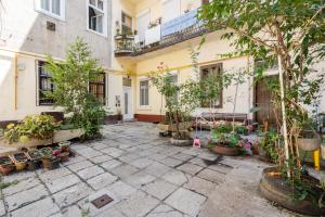 Un patio con plantas en macetas frente a un edificio. en R7 Home Apartment, en Budapest
