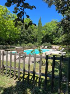 a wooden fence next to a swimming pool at Le cabanon de la bergerie in Grignan