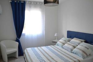 a bedroom with a bed with a blue headboard and a window at Banyuls in Latour-Bas-Elne
